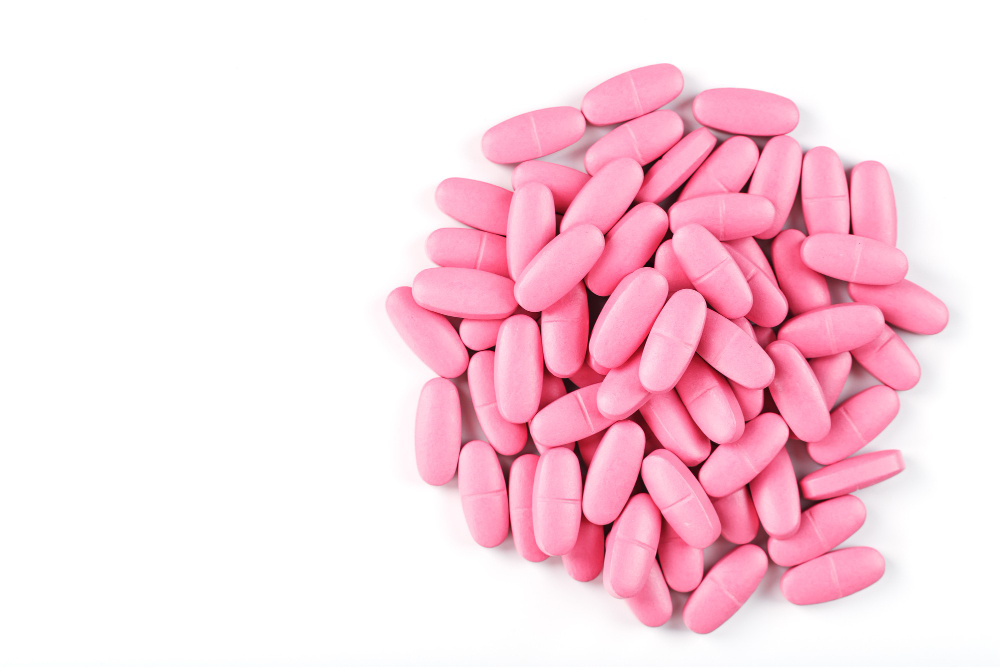 pink vitamin pills women white background