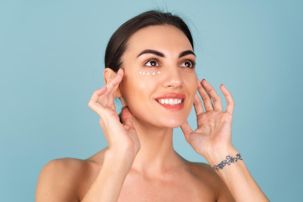 O que são Bioestimuladores de colágeno e como funcionam? 2 close up beauty portrait topless woman with perfect skin natural make up with anti aging cream dots moisturize firm skin eyes