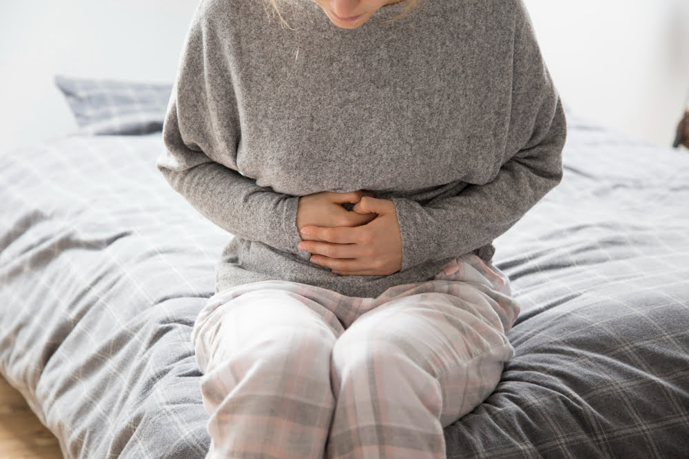 Qual a causa e diagnóstico da gastrite? 3 sick woman with hands stomach suffering from intense pain