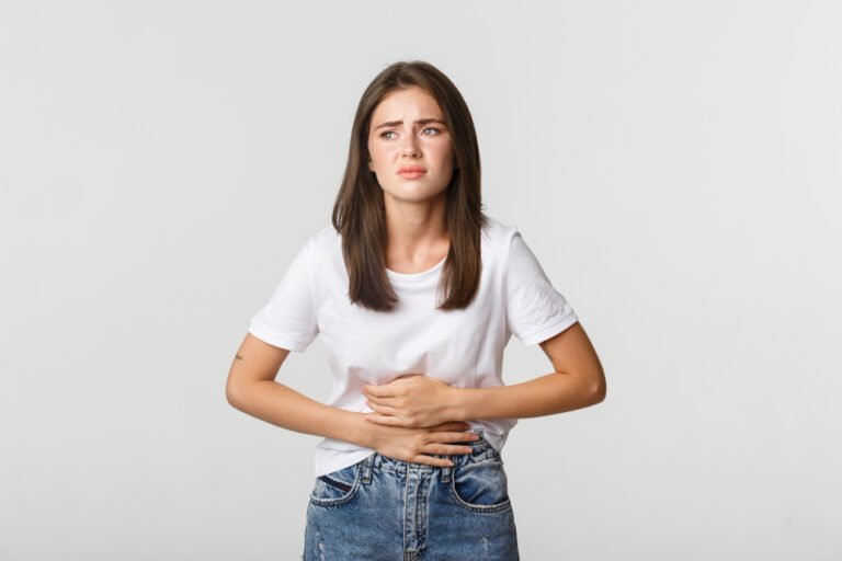 Qual a causa e diagnóstico da gastrite? 1 woman having stomach ache bending with hands belly discomfort from menstrual cramps