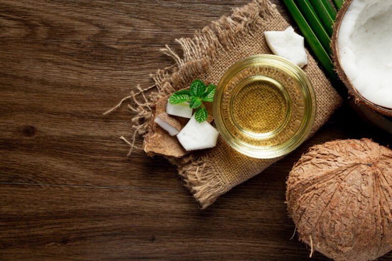 7 Usos do Óleo de Coco em Rotinas de Beleza 1 glass coconut oil put wooden dark floor